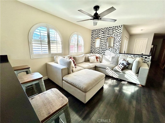 living room featuring ceiling fan and dark hardwood / wood-style floors