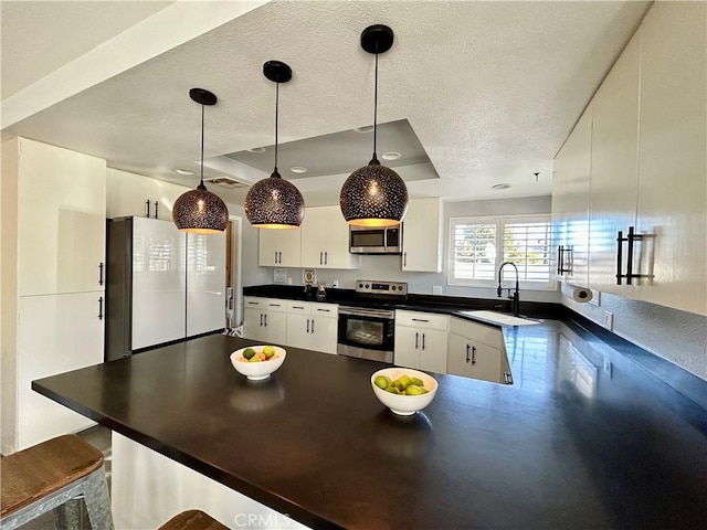 kitchen with decorative light fixtures, sink, white cabinets, and stainless steel appliances