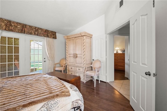 bedroom with dark hardwood / wood-style floors, access to outside, and vaulted ceiling