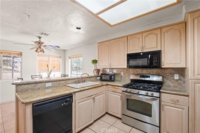 kitchen with light tile patterned floors, kitchen peninsula, ceiling fan, black appliances, and sink