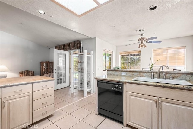 kitchen featuring ceiling fan, sink, black dishwasher, a textured ceiling, and light tile patterned floors