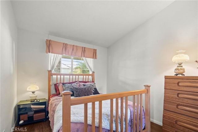 bedroom with vaulted ceiling and dark hardwood / wood-style flooring