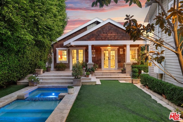 back house at dusk featuring french doors