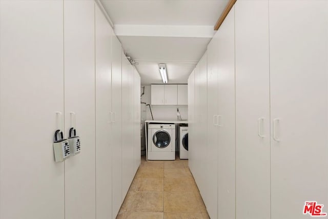 washroom with washer and clothes dryer and cabinets