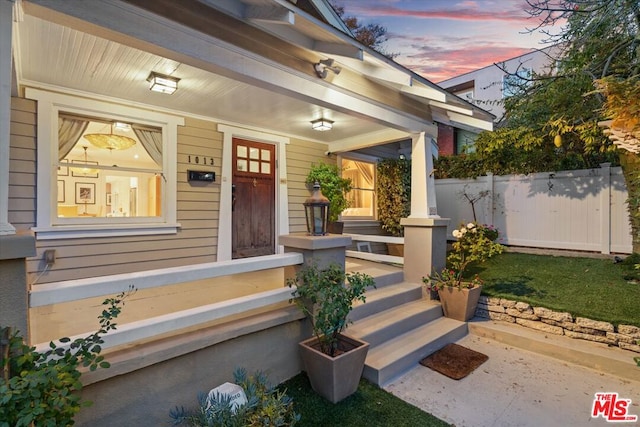 exterior entry at dusk featuring a porch