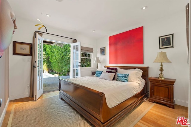 bedroom featuring light wood-type flooring, access to exterior, and french doors