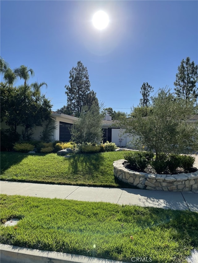 obstructed view of property featuring a front yard