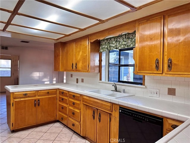 kitchen featuring sink, tile counters, black dishwasher, tasteful backsplash, and kitchen peninsula