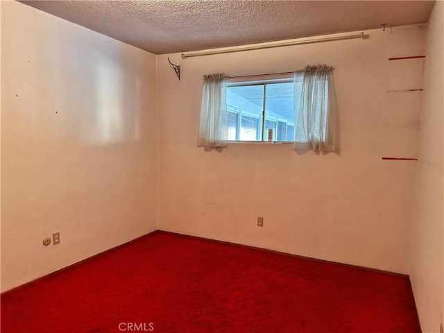 spare room featuring carpet and a textured ceiling