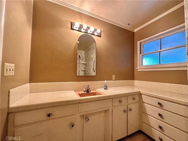 bathroom featuring tile patterned floors, crown molding, and vanity