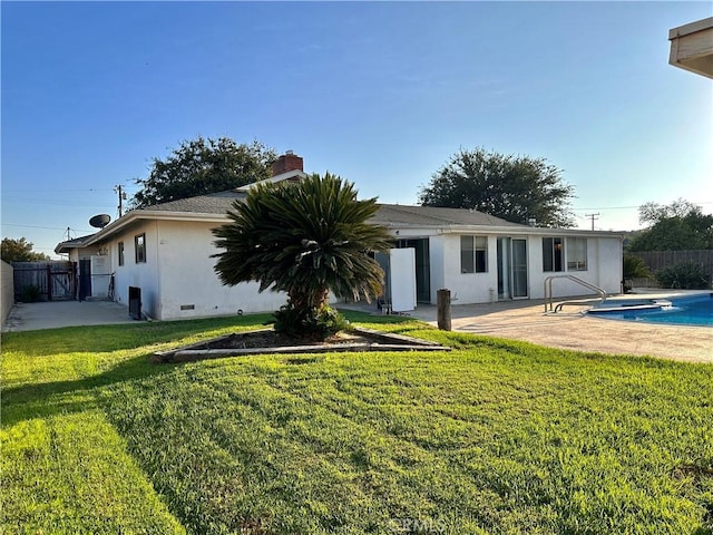 back of house with a patio area, a fenced in pool, and a yard