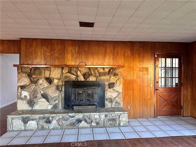 room details featuring a wood stove, wood walls, and hardwood / wood-style flooring