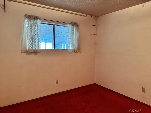 spare room featuring a textured ceiling and carpet floors