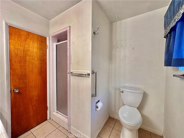 bathroom with toilet, tile patterned floors, and an enclosed shower