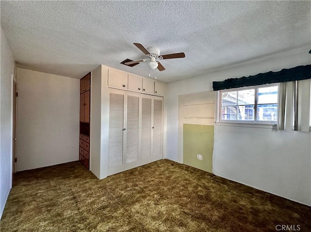 unfurnished bedroom featuring carpet flooring, ceiling fan, a textured ceiling, and a closet