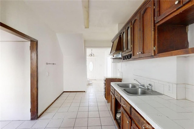 kitchen featuring tile countertops, light tile patterned floors, and sink