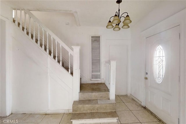 tiled foyer entrance featuring a chandelier