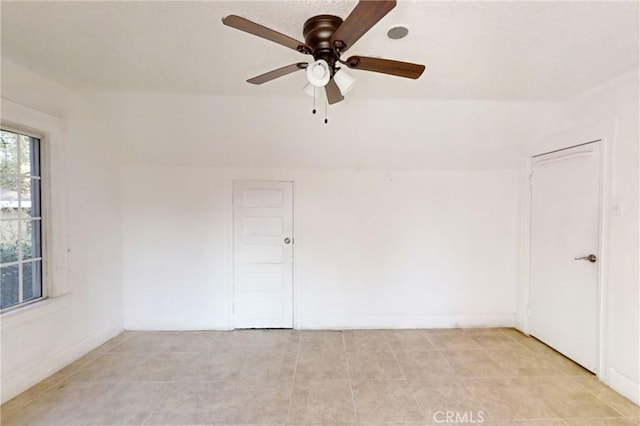 tiled spare room with ceiling fan