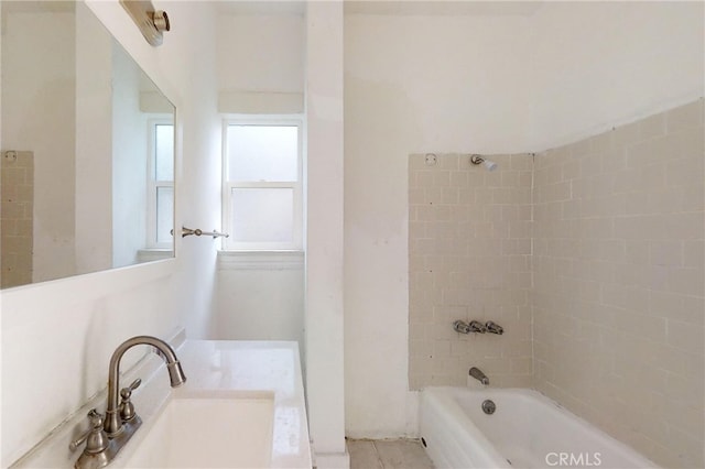 bathroom featuring vanity and tiled shower / bath