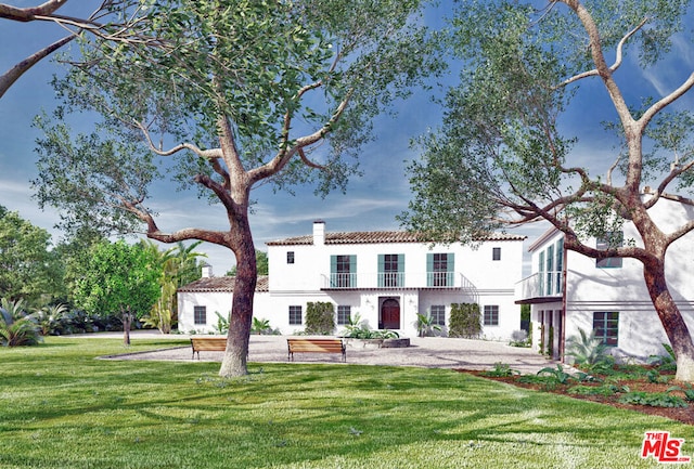 mediterranean / spanish-style house with a balcony and a front lawn