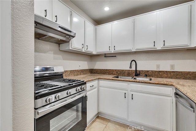 kitchen with white cabinets, stainless steel appliances, sink, and light tile patterned floors