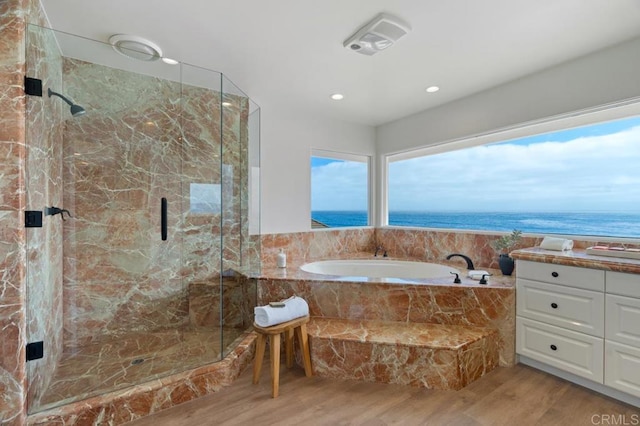 bathroom featuring separate shower and tub, a water view, and wood-type flooring