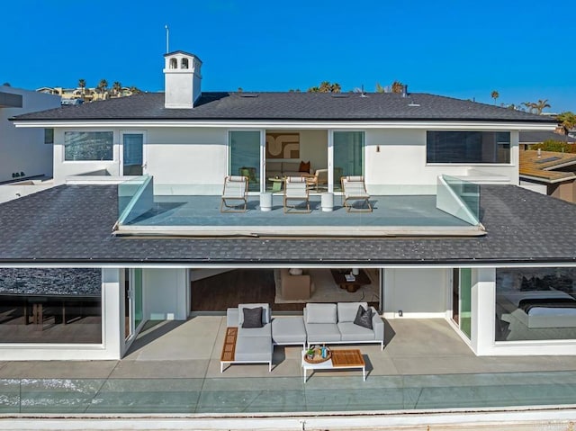 rear view of house featuring a patio area and outdoor lounge area