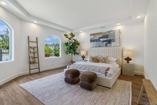 bedroom featuring hardwood / wood-style flooring and a tray ceiling