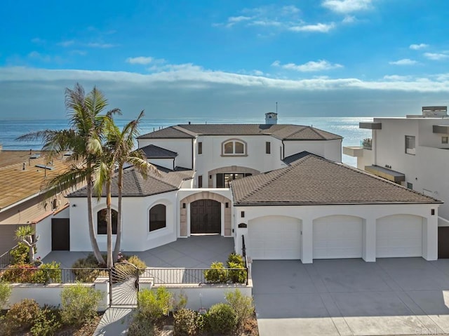 mediterranean / spanish-style home featuring a garage and a water view