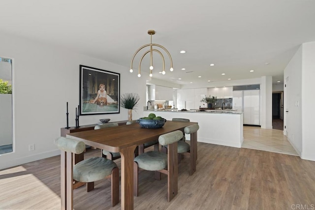 dining space with an inviting chandelier and light wood-type flooring