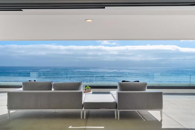 interior space with a water view, a view of the beach, and an outdoor hangout area