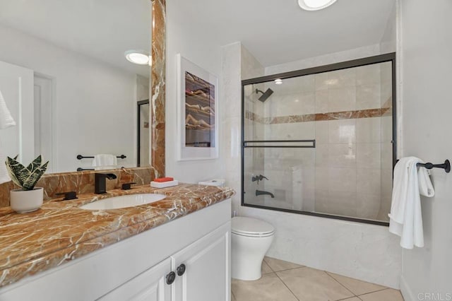 full bathroom featuring vanity, enclosed tub / shower combo, toilet, and tile patterned flooring