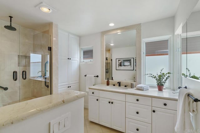 bathroom with vanity, a shower with shower door, and tile patterned floors