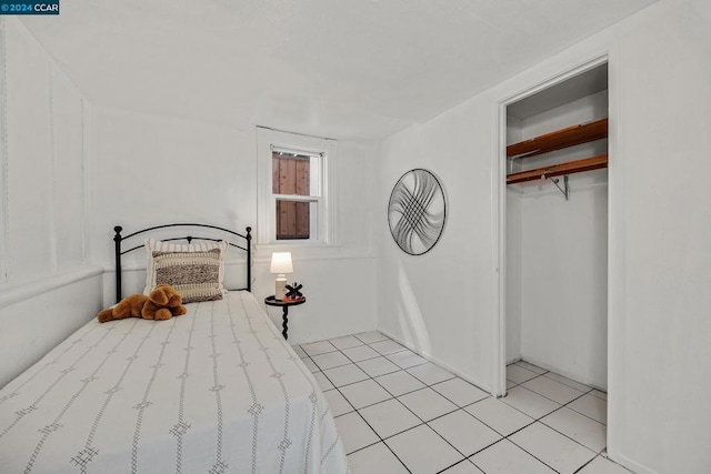 tiled bedroom with a closet