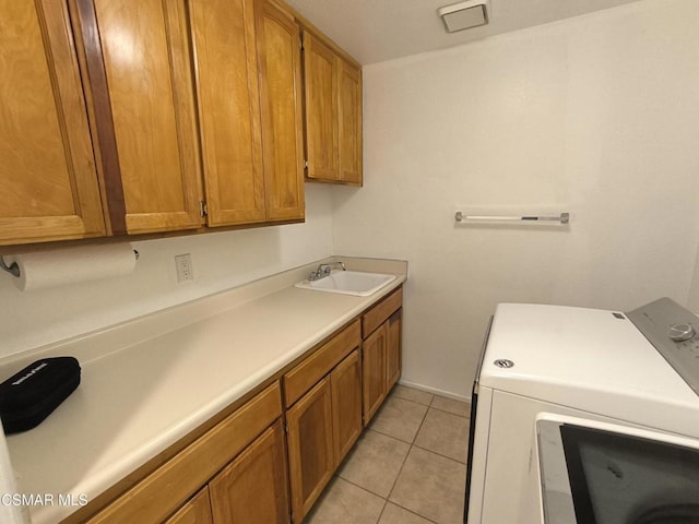 clothes washing area with cabinets, light tile patterned floors, separate washer and dryer, and sink