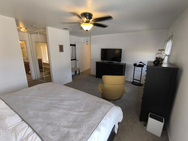 bedroom featuring dark colored carpet, ceiling fan, connected bathroom, and a closet