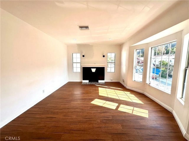 unfurnished living room featuring a healthy amount of sunlight and hardwood / wood-style flooring