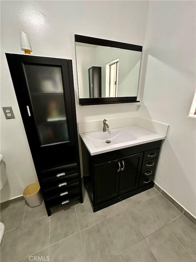 bathroom featuring tile patterned floors, vanity, and toilet