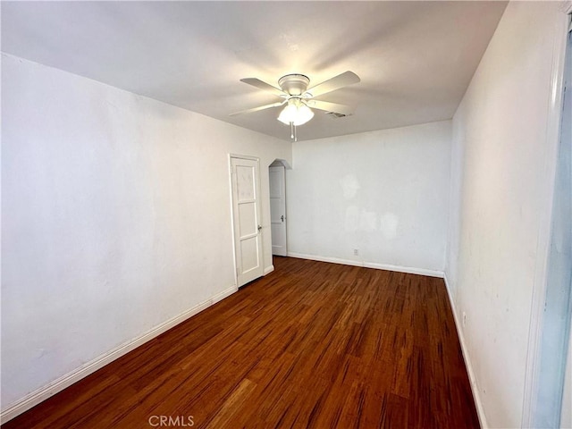 empty room featuring ceiling fan and dark wood-type flooring