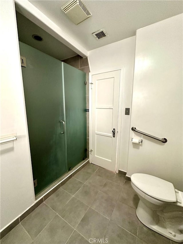 bathroom featuring toilet, tile patterned flooring, and walk in shower