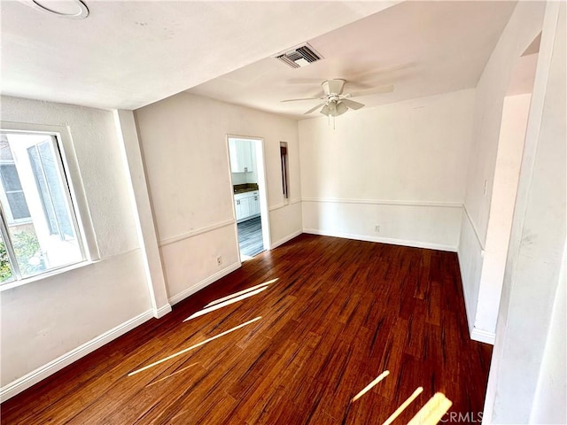 unfurnished room with dark hardwood / wood-style flooring and ceiling fan