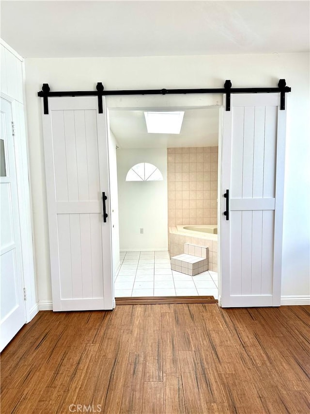 interior space with a bathtub and hardwood / wood-style flooring