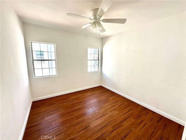 spare room featuring plenty of natural light, dark wood-type flooring, and ceiling fan