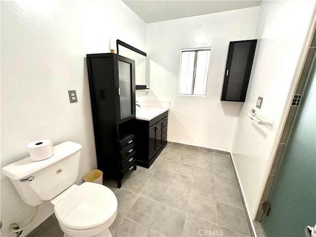 bathroom featuring tile patterned floors, vanity, a shower with shower door, and toilet