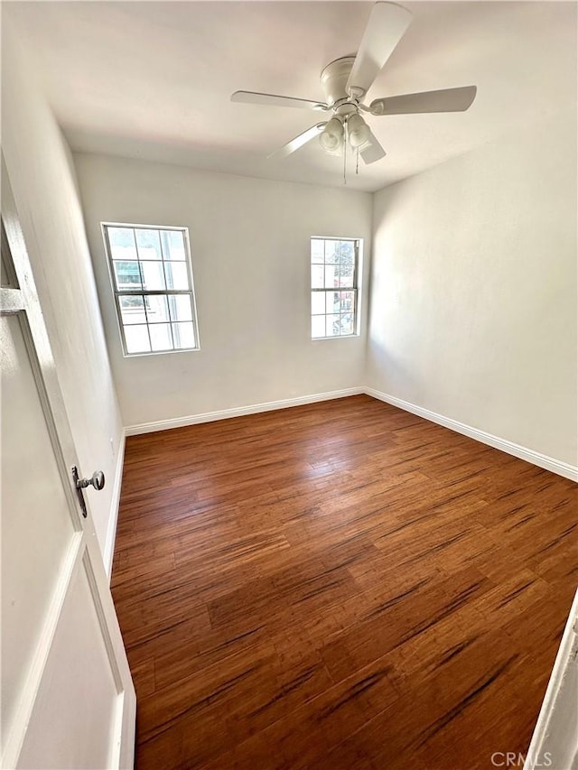 unfurnished room with dark hardwood / wood-style flooring, a wealth of natural light, and ceiling fan