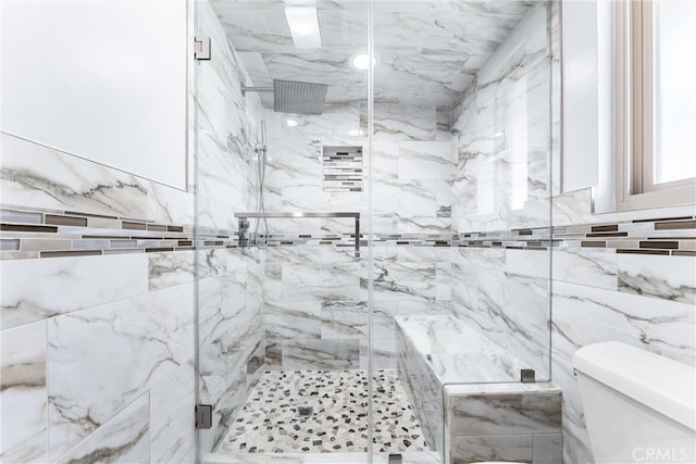 bathroom featuring tile walls, a shower with shower door, and toilet