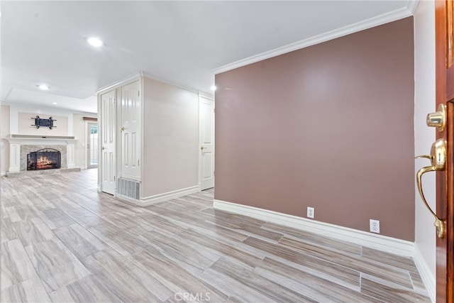 unfurnished living room with light hardwood / wood-style flooring and ornamental molding