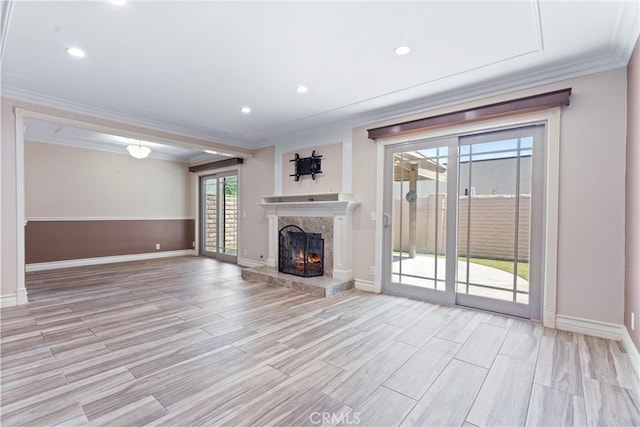 unfurnished living room with crown molding, light hardwood / wood-style flooring, and a premium fireplace