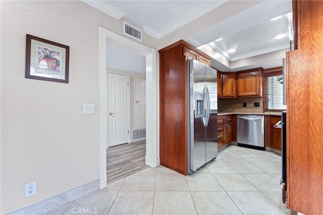 kitchen with backsplash, stainless steel appliances, crown molding, and light tile patterned floors