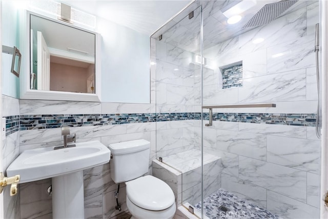 bathroom featuring tile walls, toilet, and an enclosed shower